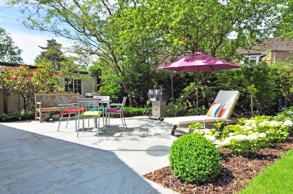 A patio with lawn furniture and an umbrella.