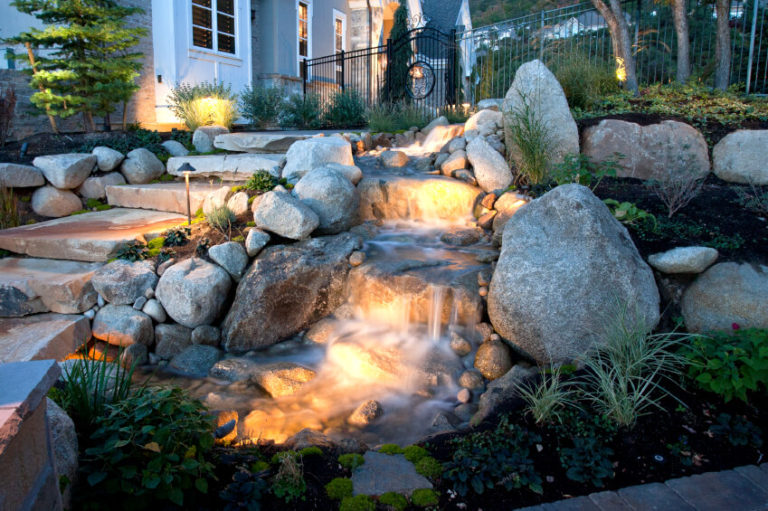 A garden with rocks and lights in the yard